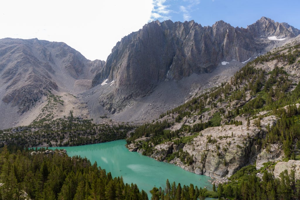 a turquoise mountain lake with towering mountains around it