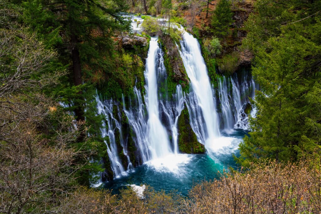 Burney Falls from a slightly elevated angle with the wide cascade and mist-filled pool visible at McArthur-Burney Falls Memorial State Park, California