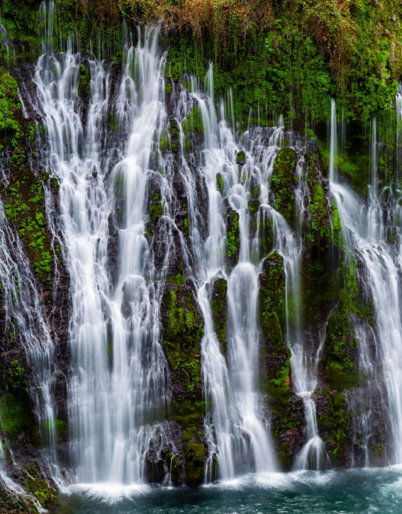 Lower section of Burney Falls with water fanning out over green moss into the pool below at McArthur-Burney Falls Memorial State Park, California