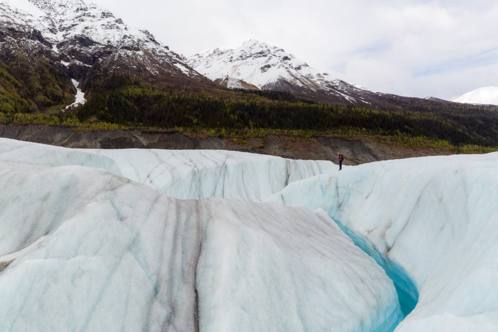 A hiker looks out at the Root Glacier. 