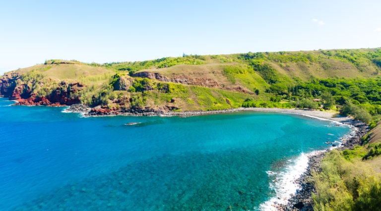 a cove used for snorkeling on maui. green slopes and deep blue water