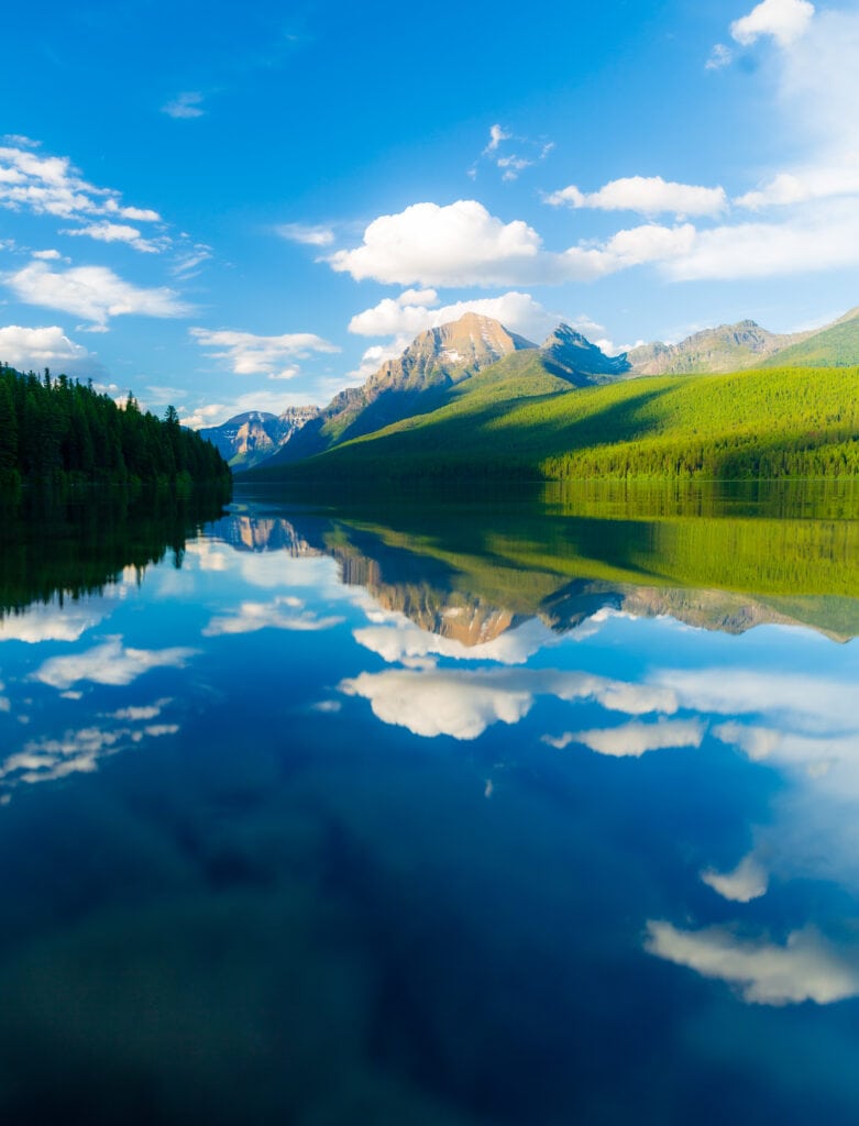 bowman lake in glacier national park with puffy clouds