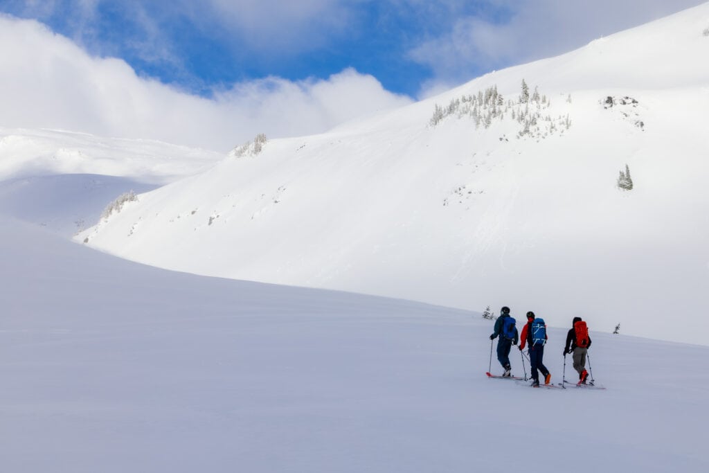 Three snowshoers walk on the snow in Mt Rainier National park. 