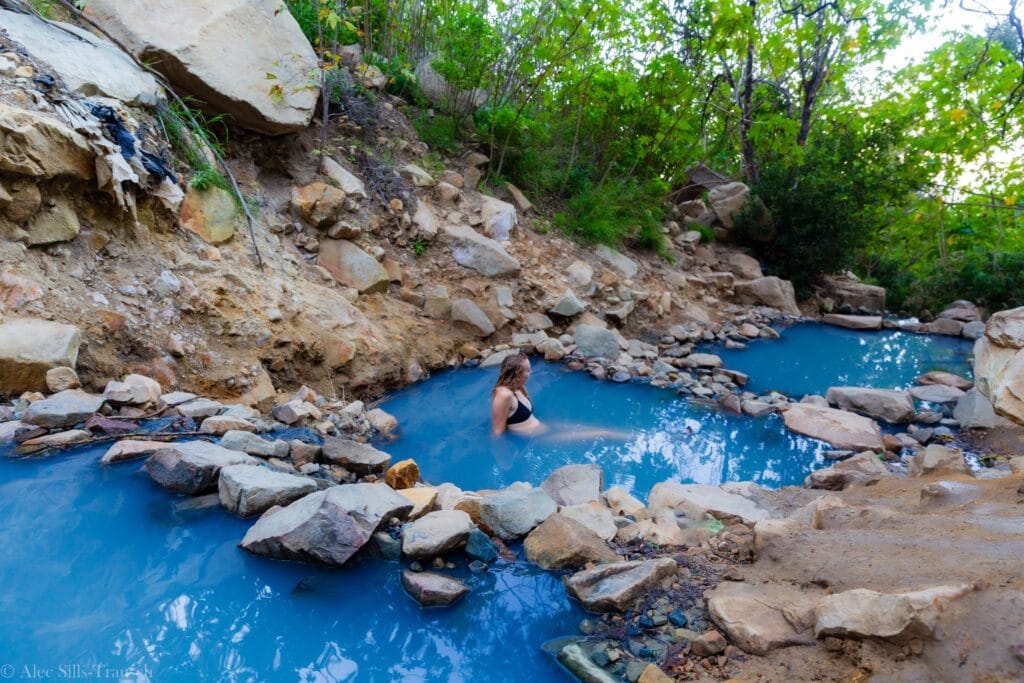 a female hiker sits in the santa barbara hot springs