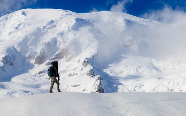 a hiker stares out at mt. rainier in washington