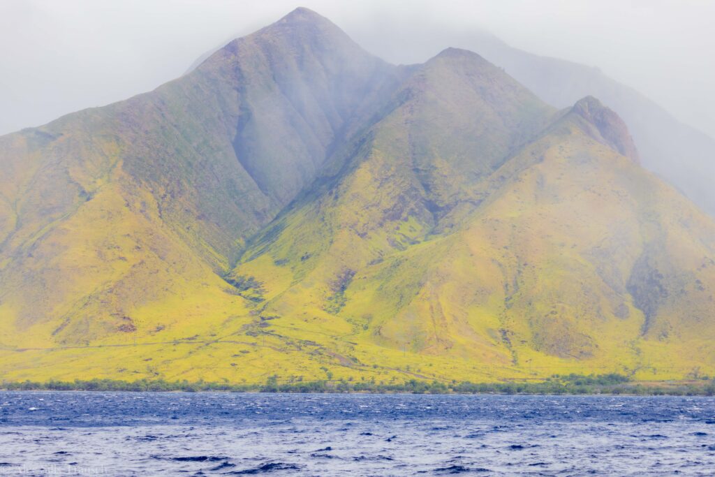 looking back at maui's mountains from the open ocean