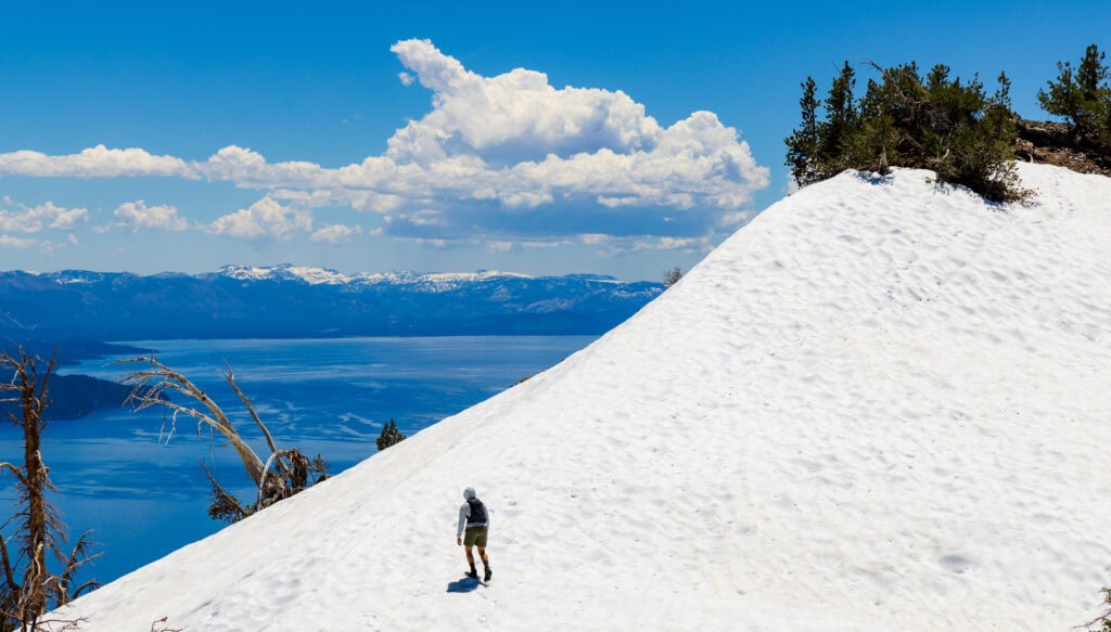 a hiker on the snow above lake tahoe heading to rose knob