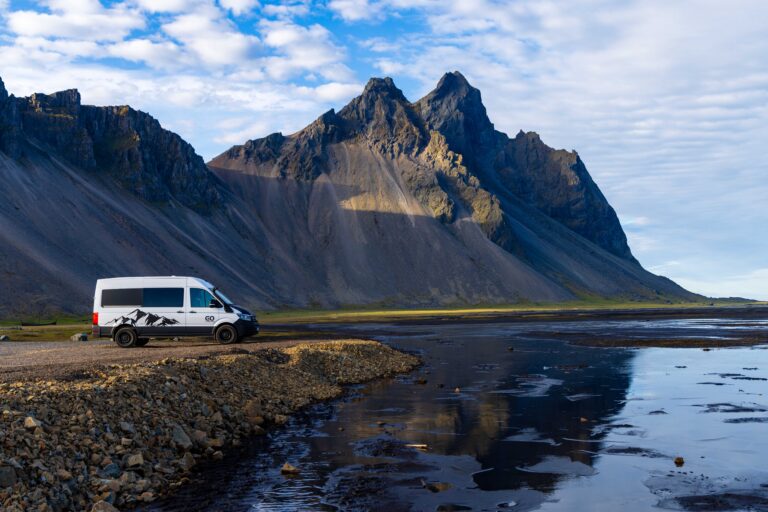a camper van parked with a large mountain behind