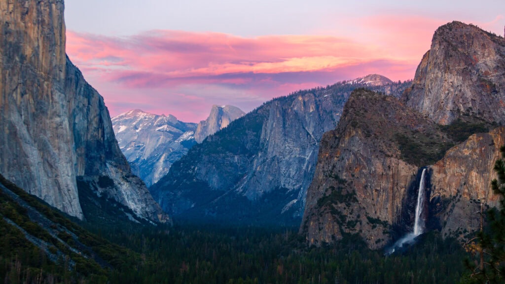 sunset photography from yosemite's tunnel view there's a waterfall on the right, half dome in center, and el cap on the left