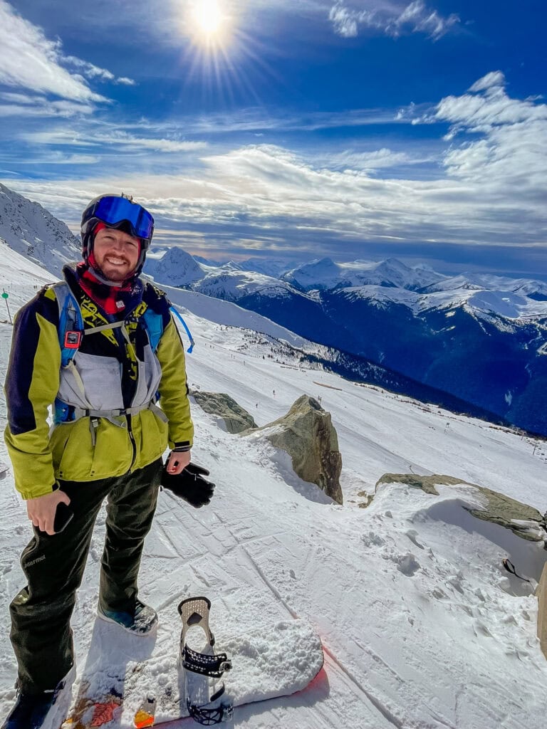 a snowboarder smiles at the camera
