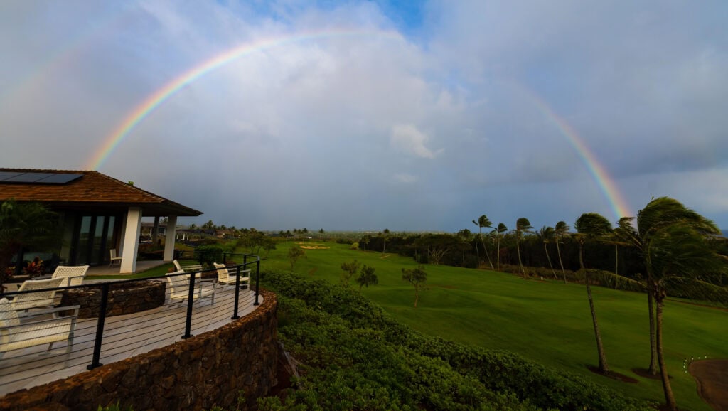 a full rainbow over a golf course in kauai