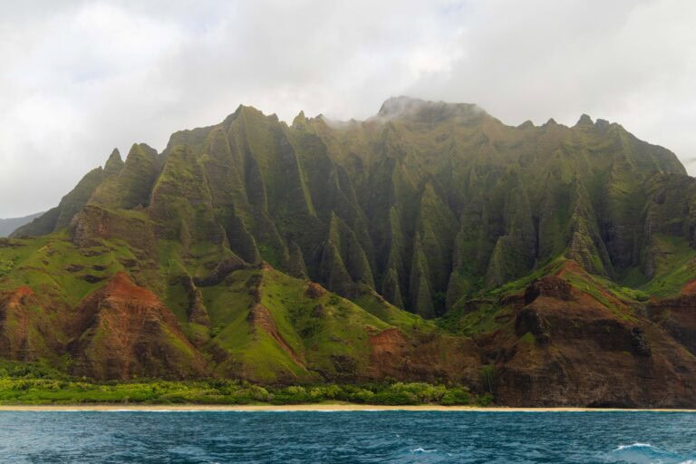 The spires and peaks of the Na Pali coast seen from a boat tour. It's one of the best things to do in Kauai.