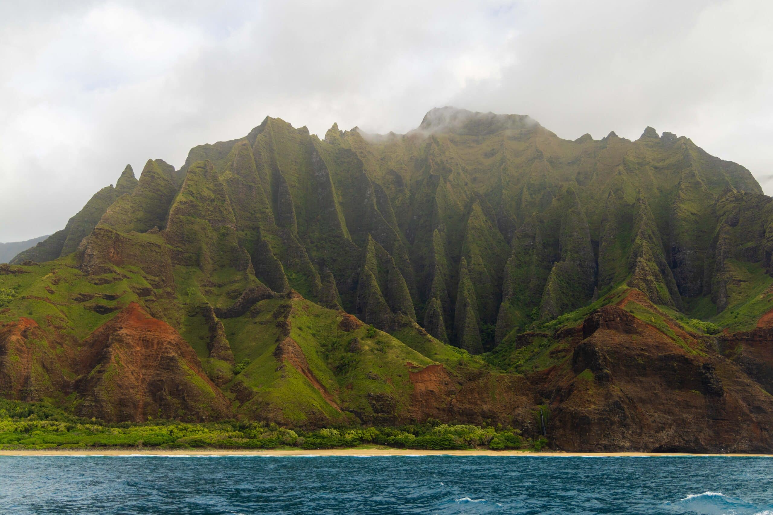 The spires and peaks of the Na Pali coast seen from a boat tour. It's one of the best things to do in Kauai.