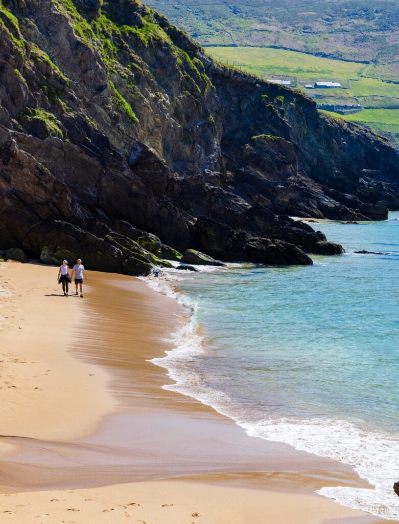 a couple walk on the beach on the dingle peninsula
