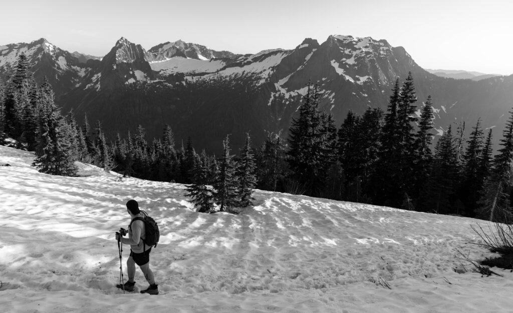 a hiker walks on the snow in the alpine on one of the mountain loop highway hikes