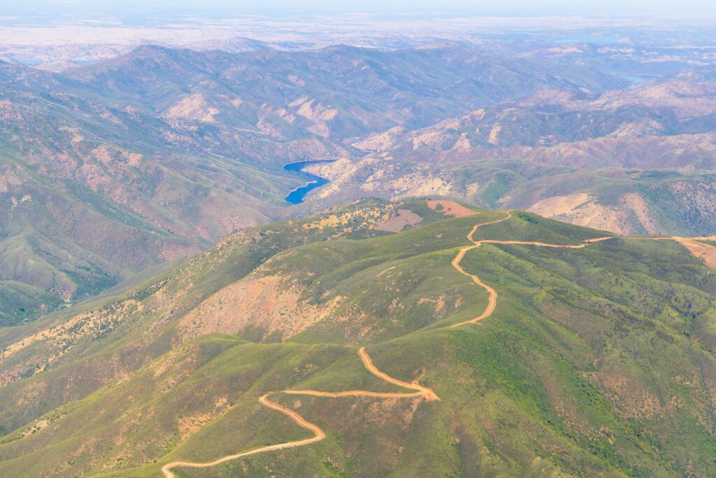 a dirt road zig zags on top of a hill outside of yosemite valley 