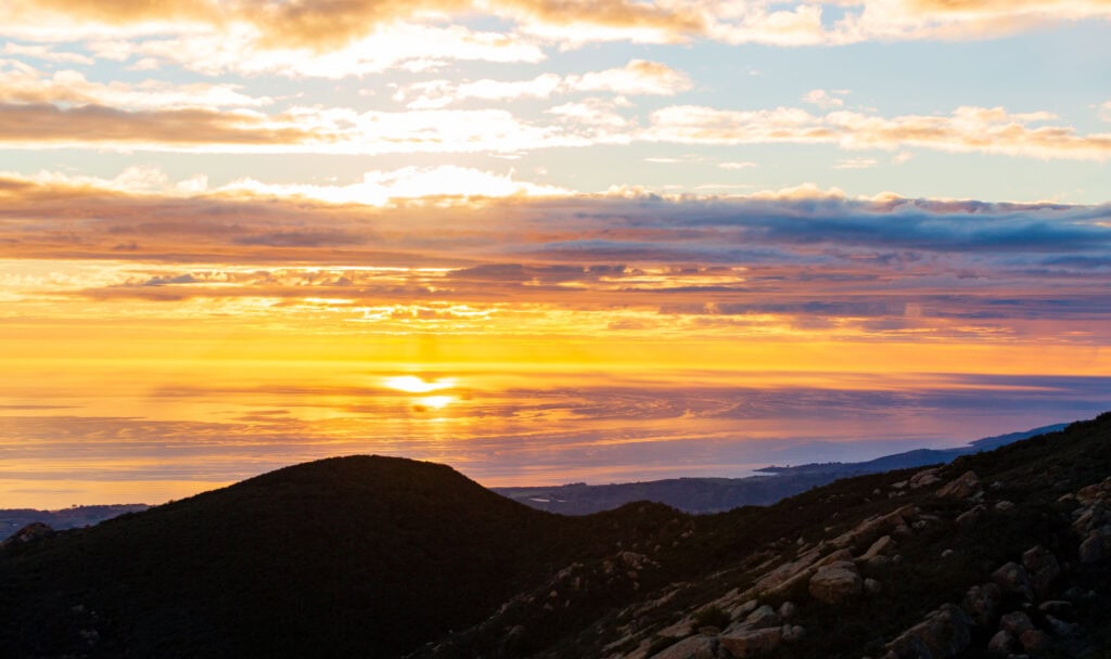 looking at the ocean at sunset with colorful clouds in the sky