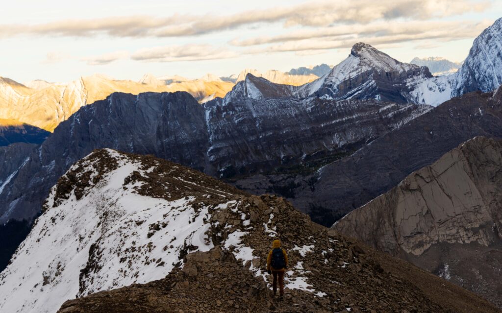 hiker heads off the snow peak summit back to burstall pass trail