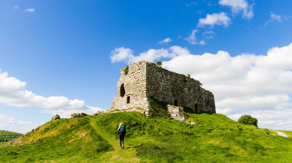 a tourist walks on the path towards the rock of dunamase in ireland