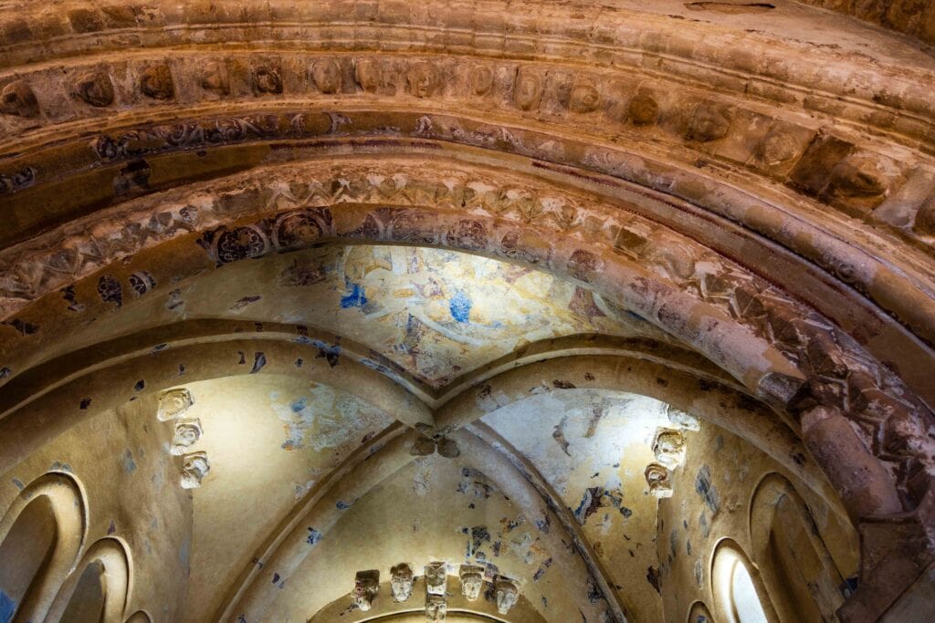 the inside of cormac's chapel at the rock of cashel with painting on the roof