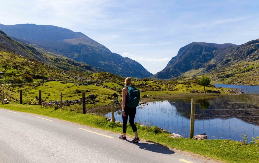 a female hiker on the road walking towards the gap of dunloe