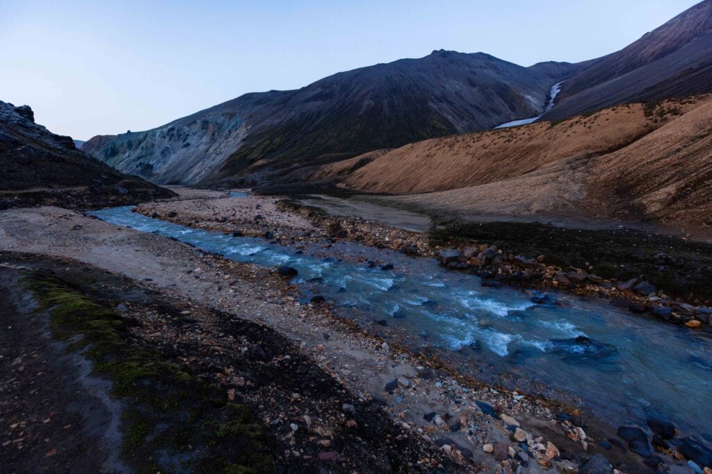 the creek trail leading towards the mountains and lava fields in landmannalaugar