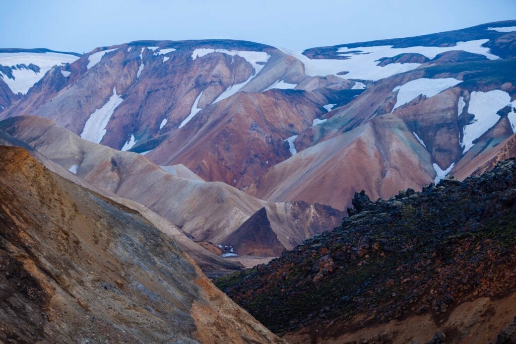 multi colroed mountains wiht snow on it