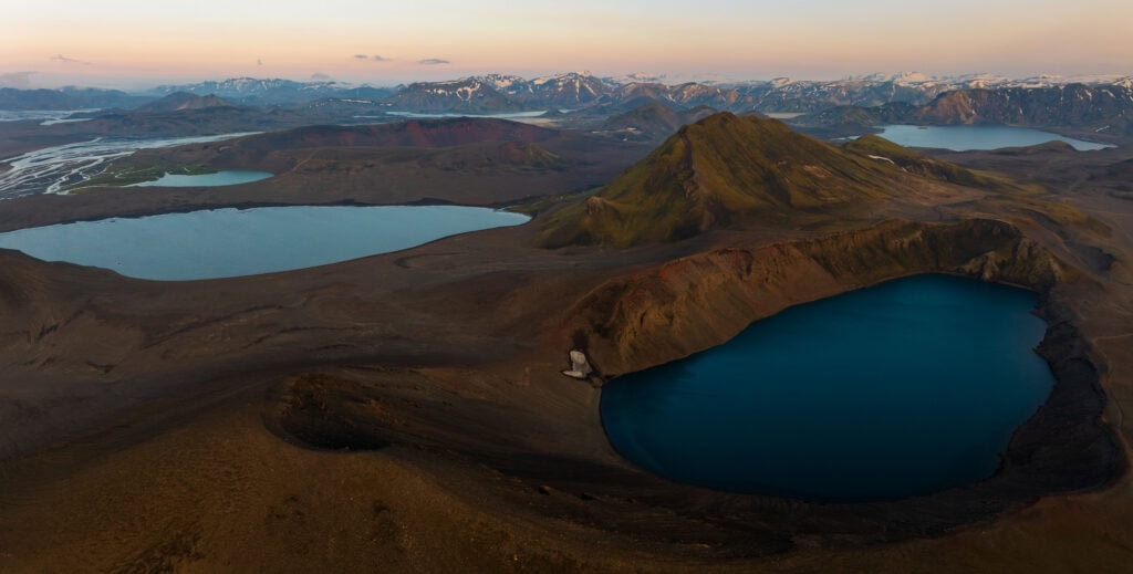 two lakes in the icelandic highlands with mountains behind it. this is viewed on the way to landmannalaugar