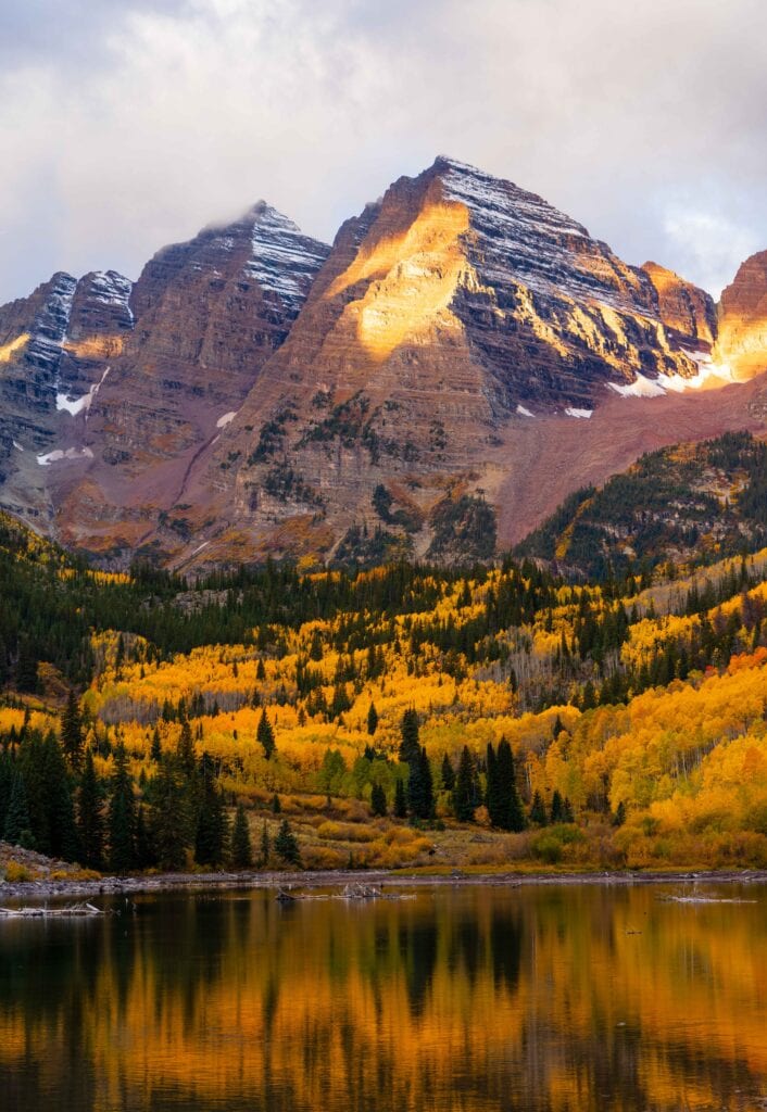 sunlight hitting the peaks after sunrise at maroon bells