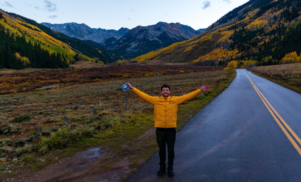 the author smiles for the camera wearing a red down jacket