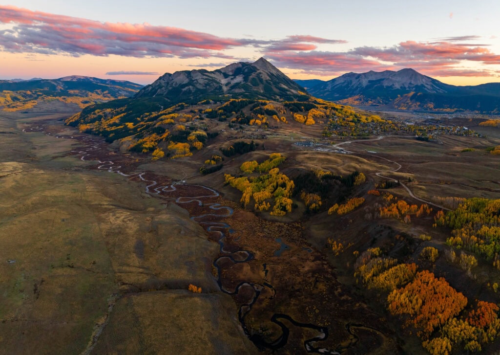striking sunset colors above mount crested butte with a zigzagging river running below