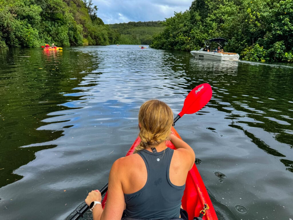 a female sitting in front of the kayak paddling