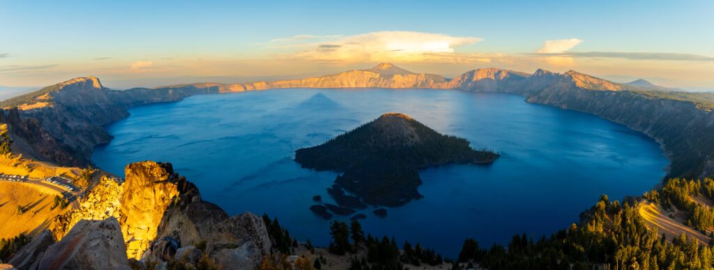 sunset at crater lake with the very tip of wizard island illuminated