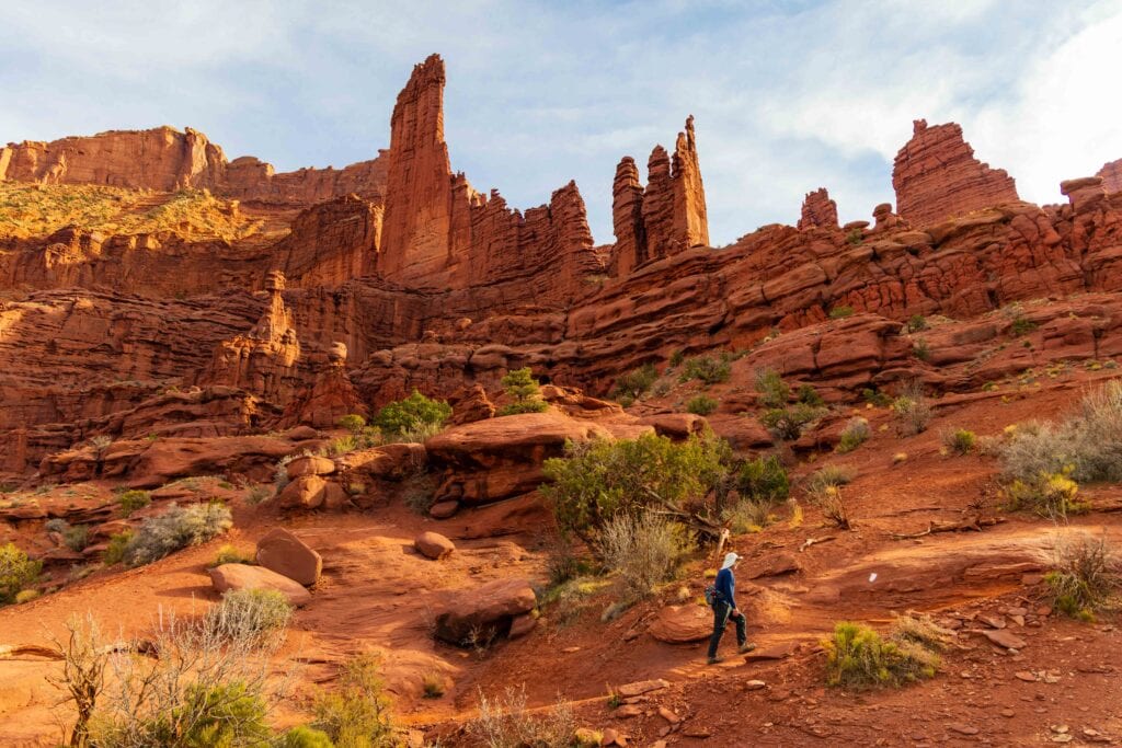 a hiker walks on the fisher towers trail near moab in utah