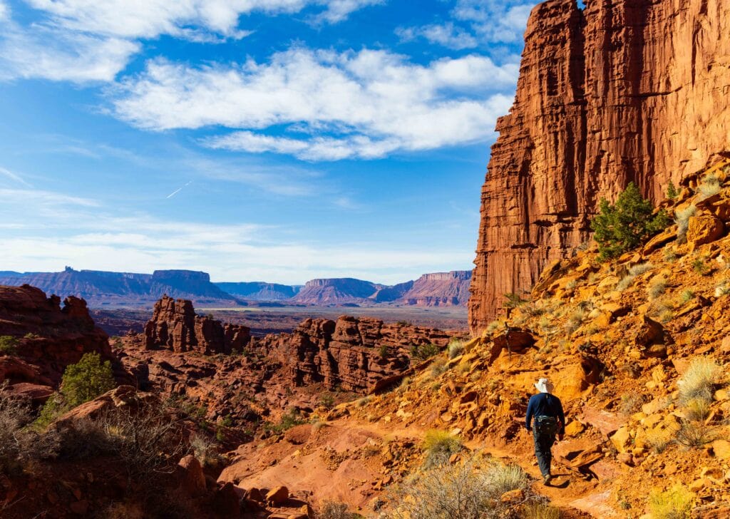 a hiker on the trail near moab surrounded by red rock