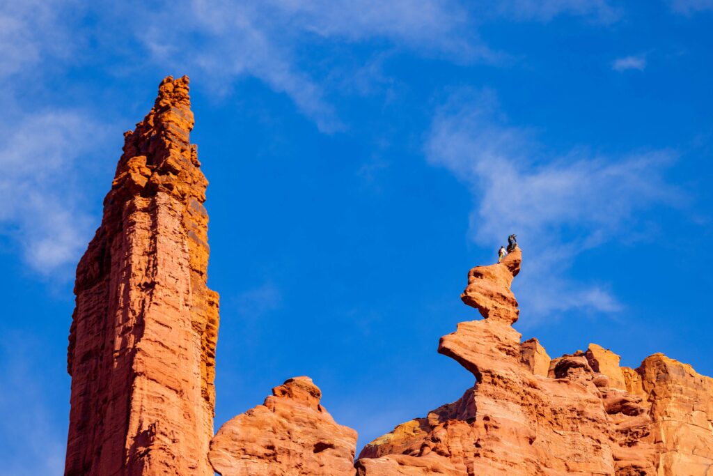 two climbers at the very top of fisher towers