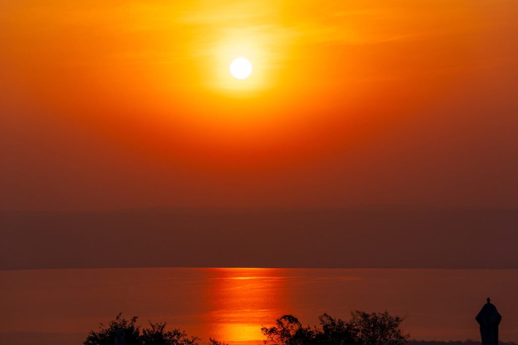 the sun rising over lake ihema in rwanda