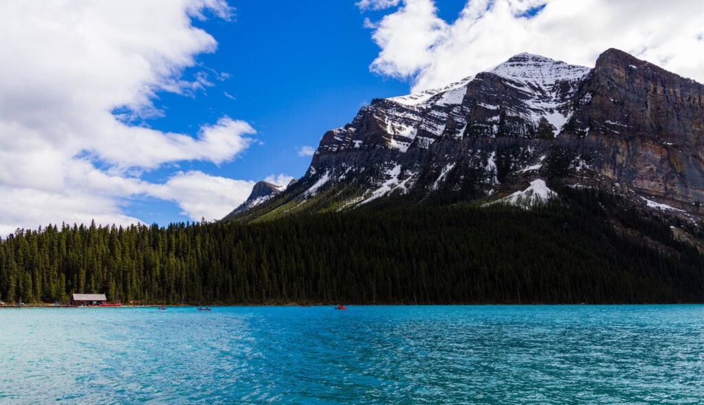 the boat house and canoes in the water in lake louise