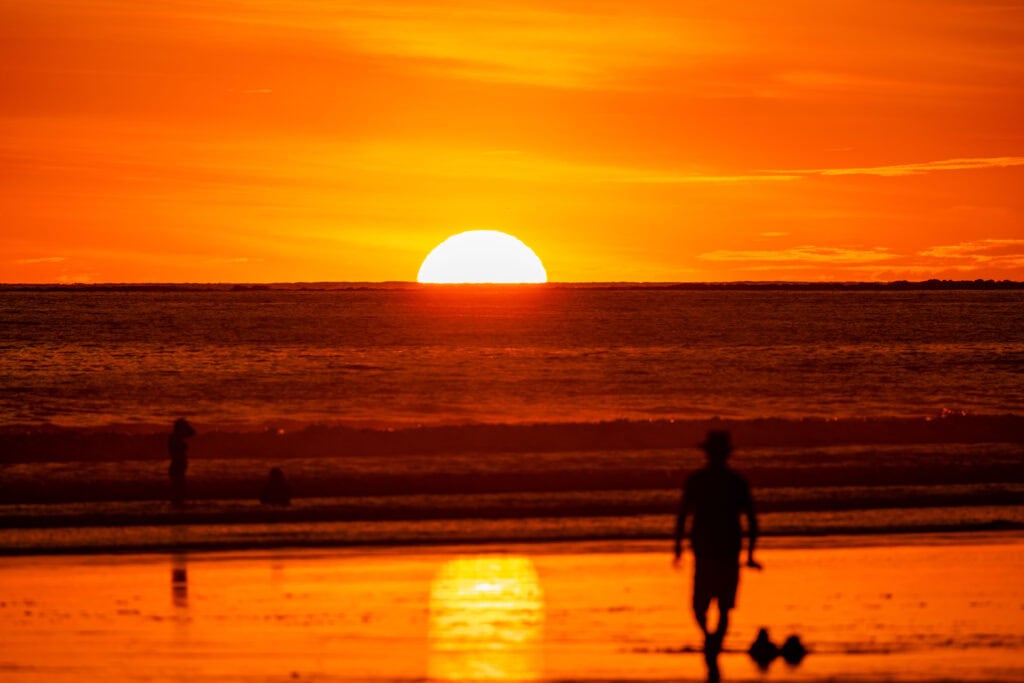 the sun sets on the horizon and ocean