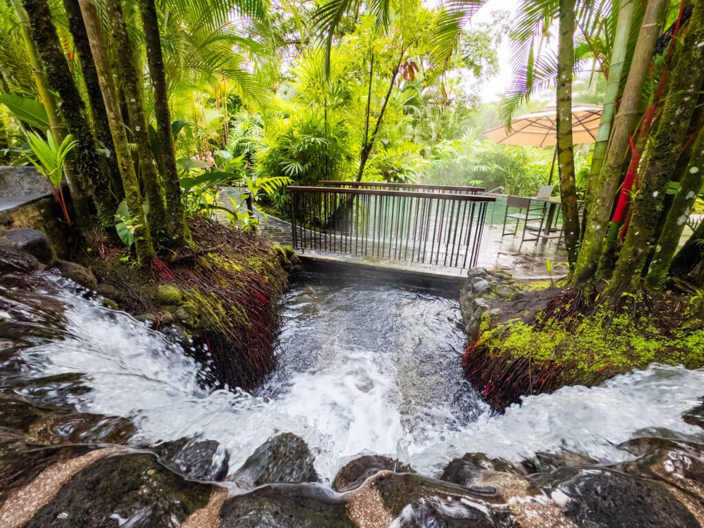 one of the pools at tabacon hot springs resort with a bridge