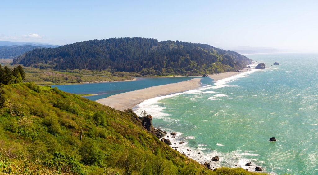 a river and ocean meet on the coast of california