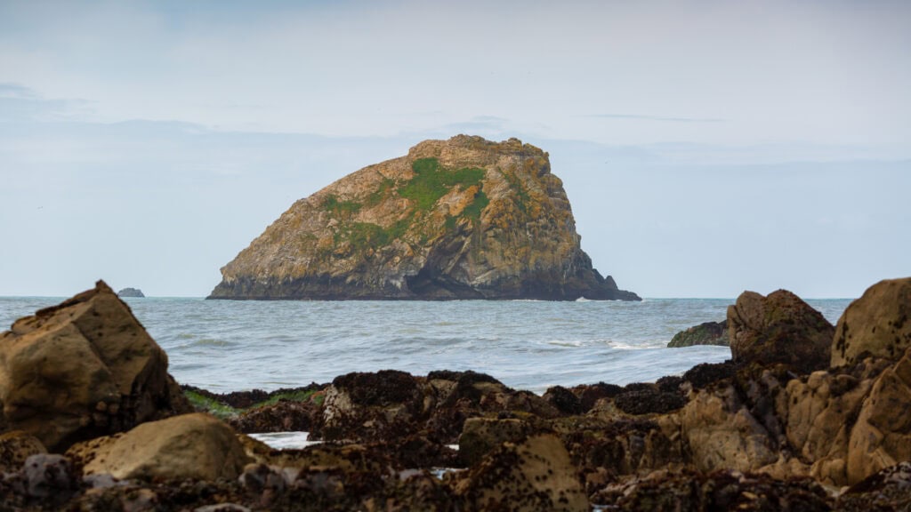 a big rock sits off shore