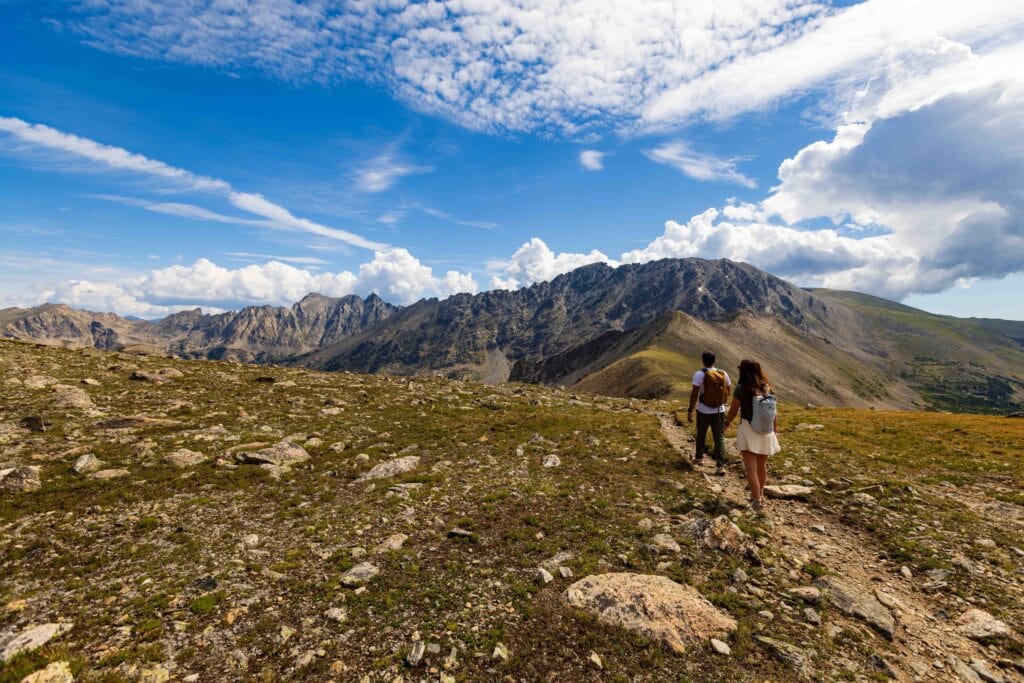 two hikers hiking on a trail near arapaho pass
