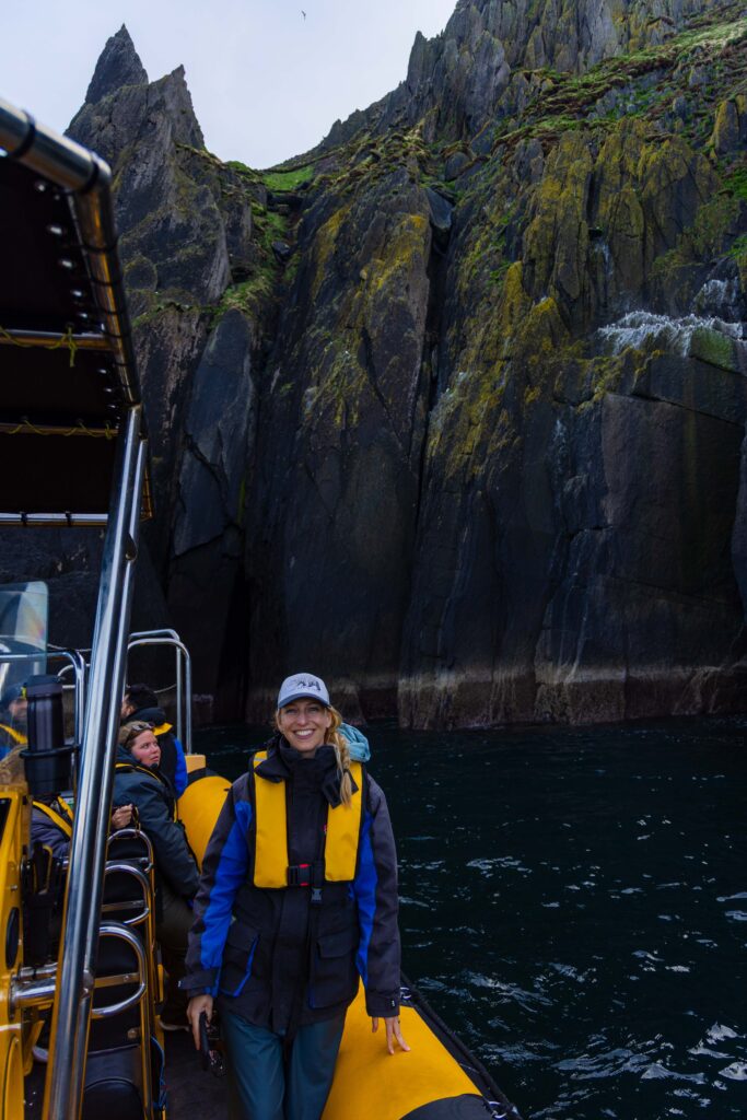 a female tourst smiles at the camera near cathedral rocks on the sea safari