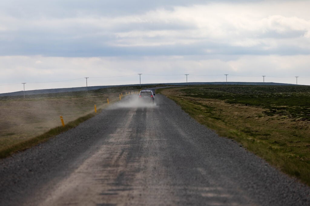 a car drives and kicks up dust on the f35 road