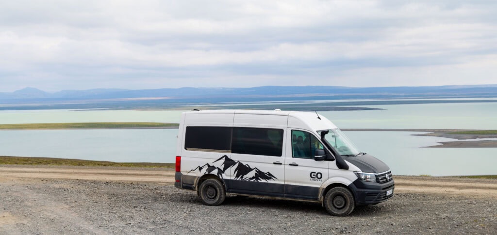 a camper van sites alongside a lake near the f35 road in iceland