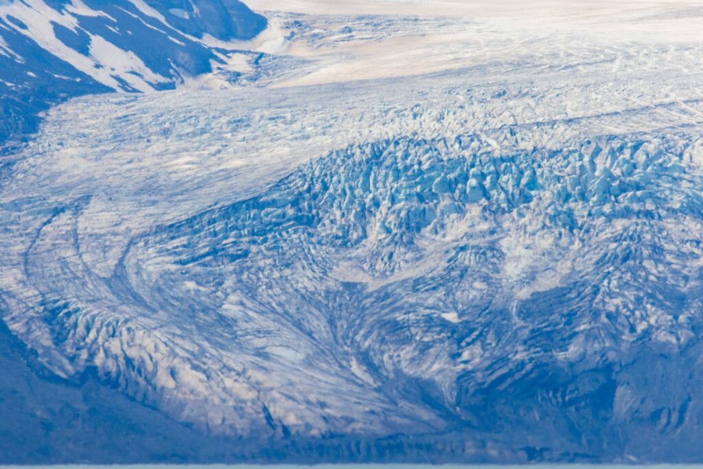 a glacier winding towards a turqoise river as seen along the f35 road