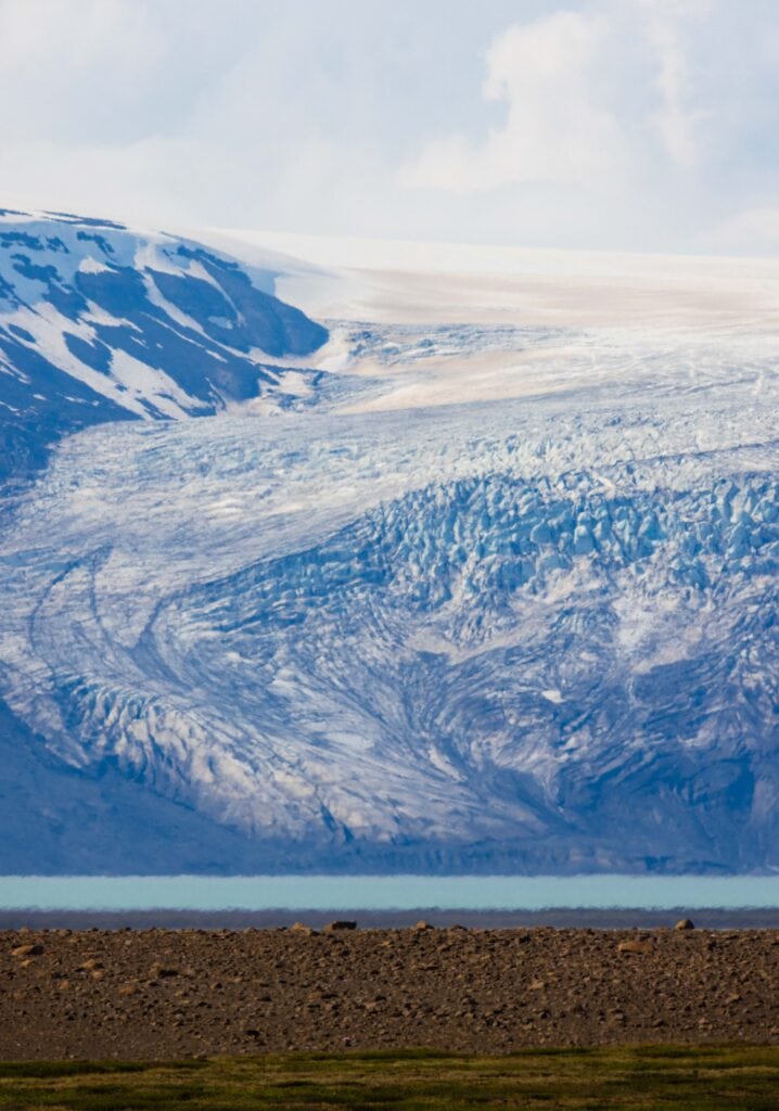 a glacier winding towards a turqoise river as seen along the f35 road