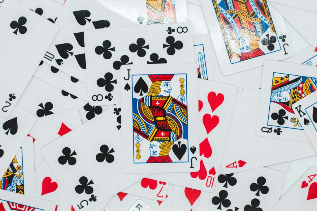 various playing cards with a joker card on top and most visible