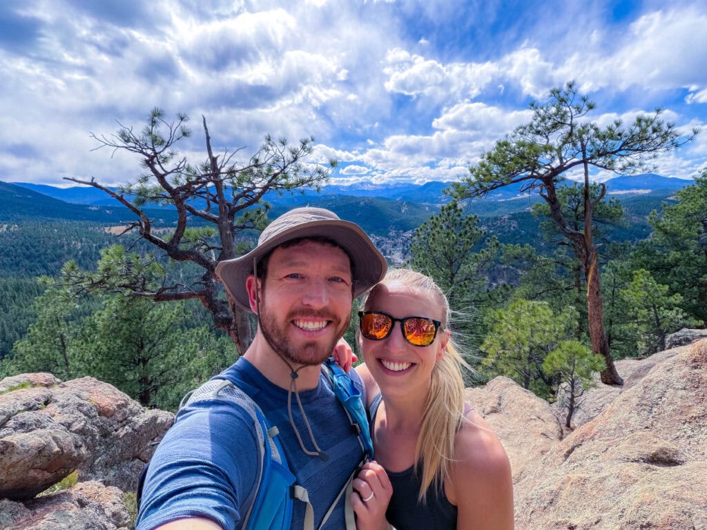 two hikers smile at the camera on top of panorama point one of the hikes near denver i recommend.